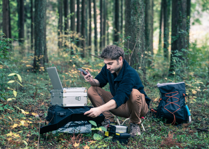 Student macht technische Messungen im Wald